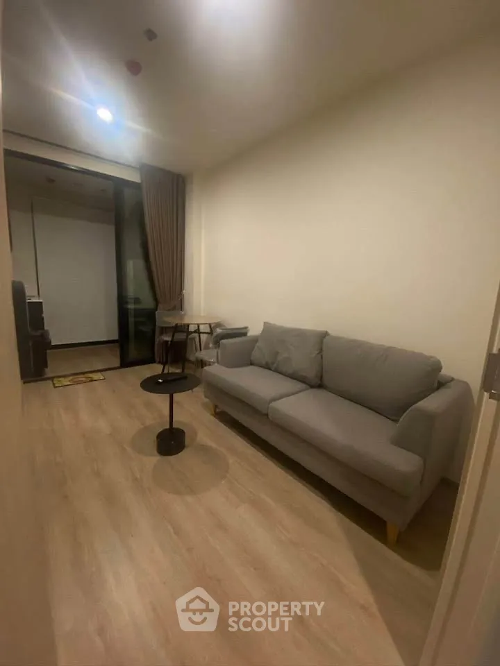 Cozy living room with modern sofa and wooden flooring, perfect for relaxation.
