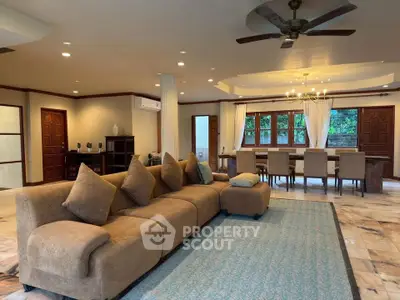 Spacious living room with elegant dining area and plush seating in a luxurious home.