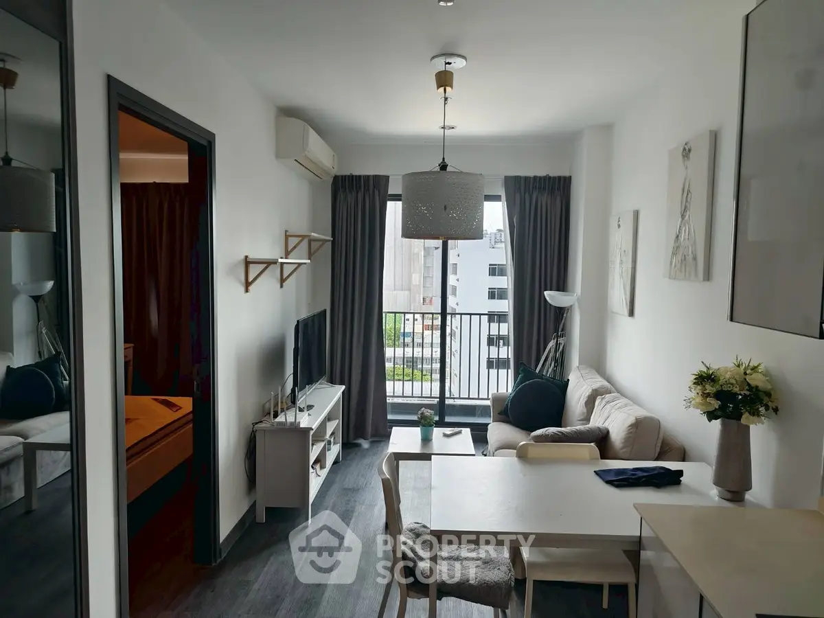 Modern living room with balcony view, stylish decor, and cozy seating area.