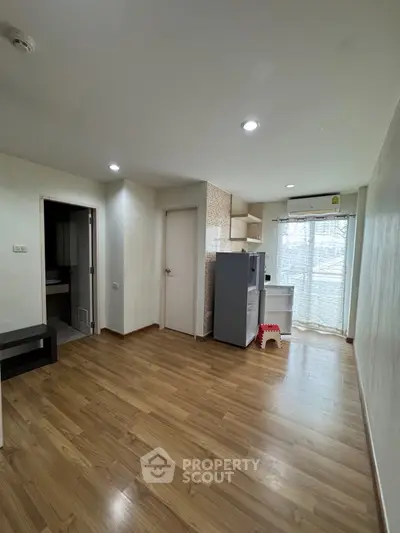 Spacious apartment with wooden flooring, modern kitchen, and ample natural light.