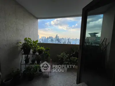 Stunning city view from a cozy balcony with lush greenery and open sky.