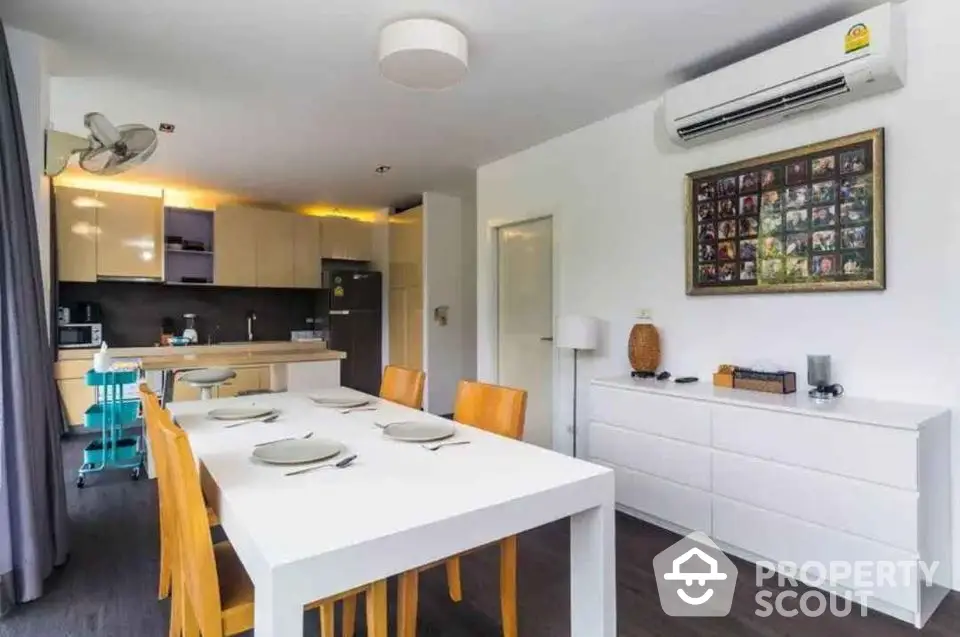 Modern dining area with sleek kitchen and stylish decor in open layout apartment.