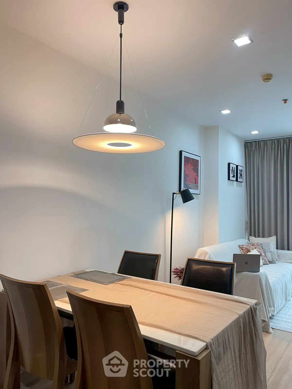Modern dining area with elegant lighting and cozy seating in a stylish apartment.