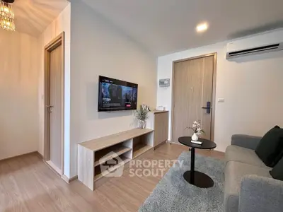 Modern living room with sleek design, featuring a wall-mounted TV, cozy sofa, and stylish wooden furniture.