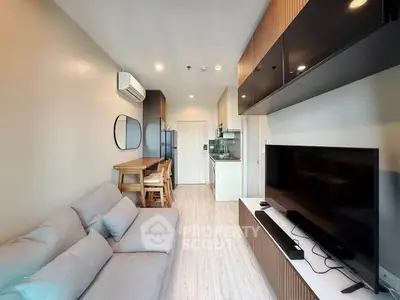 Modern living room with sleek furniture and open kitchen layout in a stylish apartment.