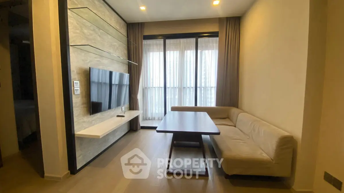 Modern living room with sleek TV setup and cozy corner sofa.