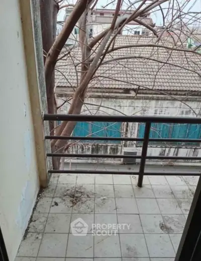Cozy balcony with tiled floor and tree view, perfect for relaxation and fresh air.