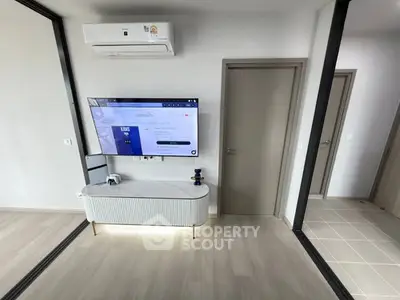 Modern living room with sleek TV setup and air conditioning unit