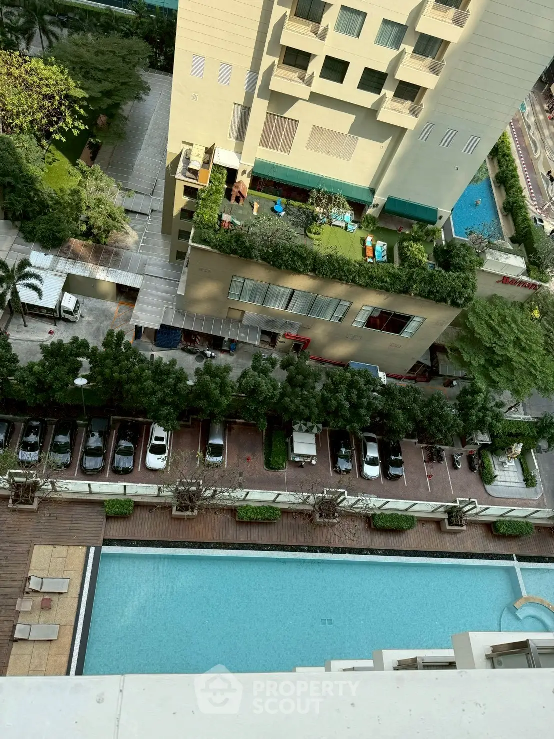Stunning aerial view of luxury apartment building with rooftop garden and swimming pool.