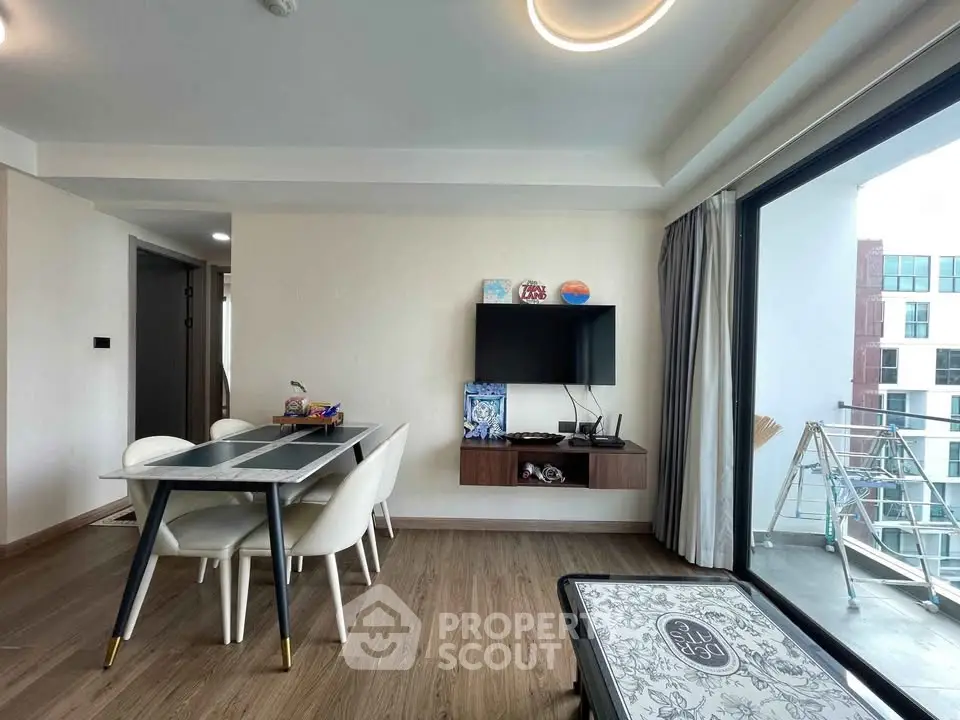 Modern living room with dining area and balcony view in a stylish apartment.