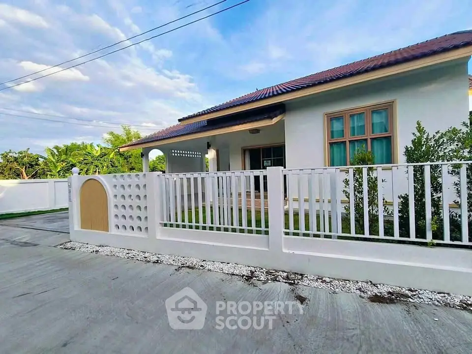 Charming single-story home with a fenced yard and lush greenery, perfect for family living.