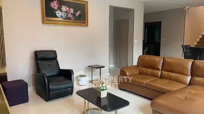 Elegant living room with leather sofa and armchair, modern decor, and stylish coffee table.