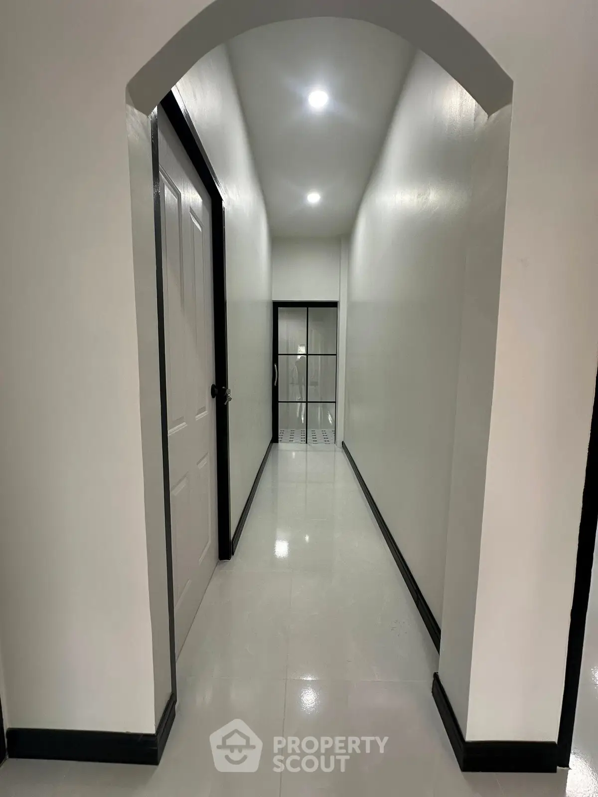 Sleek modern hallway with glossy floors and recessed lighting in a contemporary building.