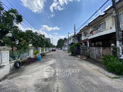 Charming suburban street view with row houses and clear blue sky, perfect for family living.