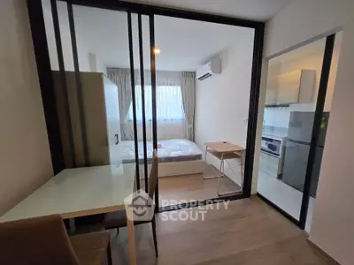 Modern studio apartment with sliding glass doors and compact kitchen