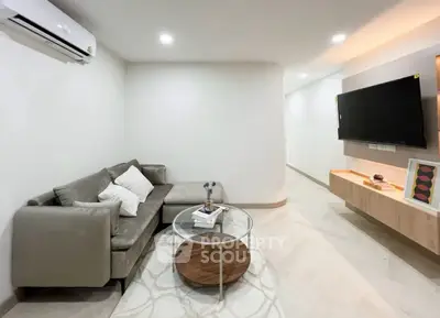 Modern living room with sleek furniture and wall-mounted TV, perfect for contemporary living.