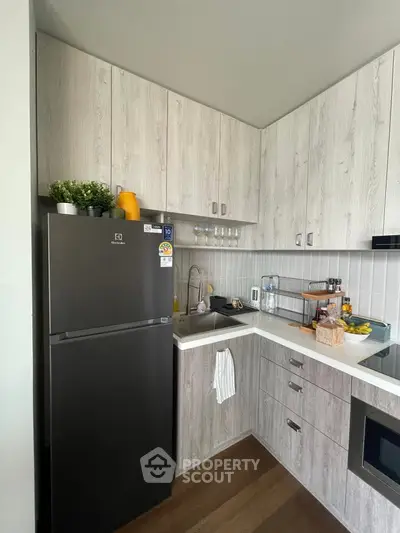 Modern kitchen with sleek cabinetry and appliances in compact layout