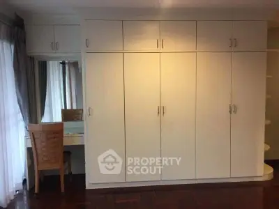 Spacious bedroom with built-in wardrobe and elegant dressing area.