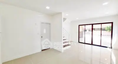 Spacious modern living room with large windows and staircase