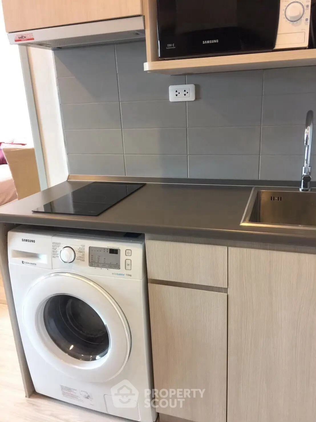 Modern kitchen with built-in appliances including washing machine and microwave.