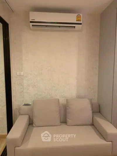 Cozy living room with modern air conditioning and comfortable sofa, perfect for relaxation.