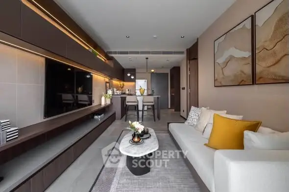 Modern living room with open kitchen, stylish decor, and cozy seating area in a contemporary apartment.