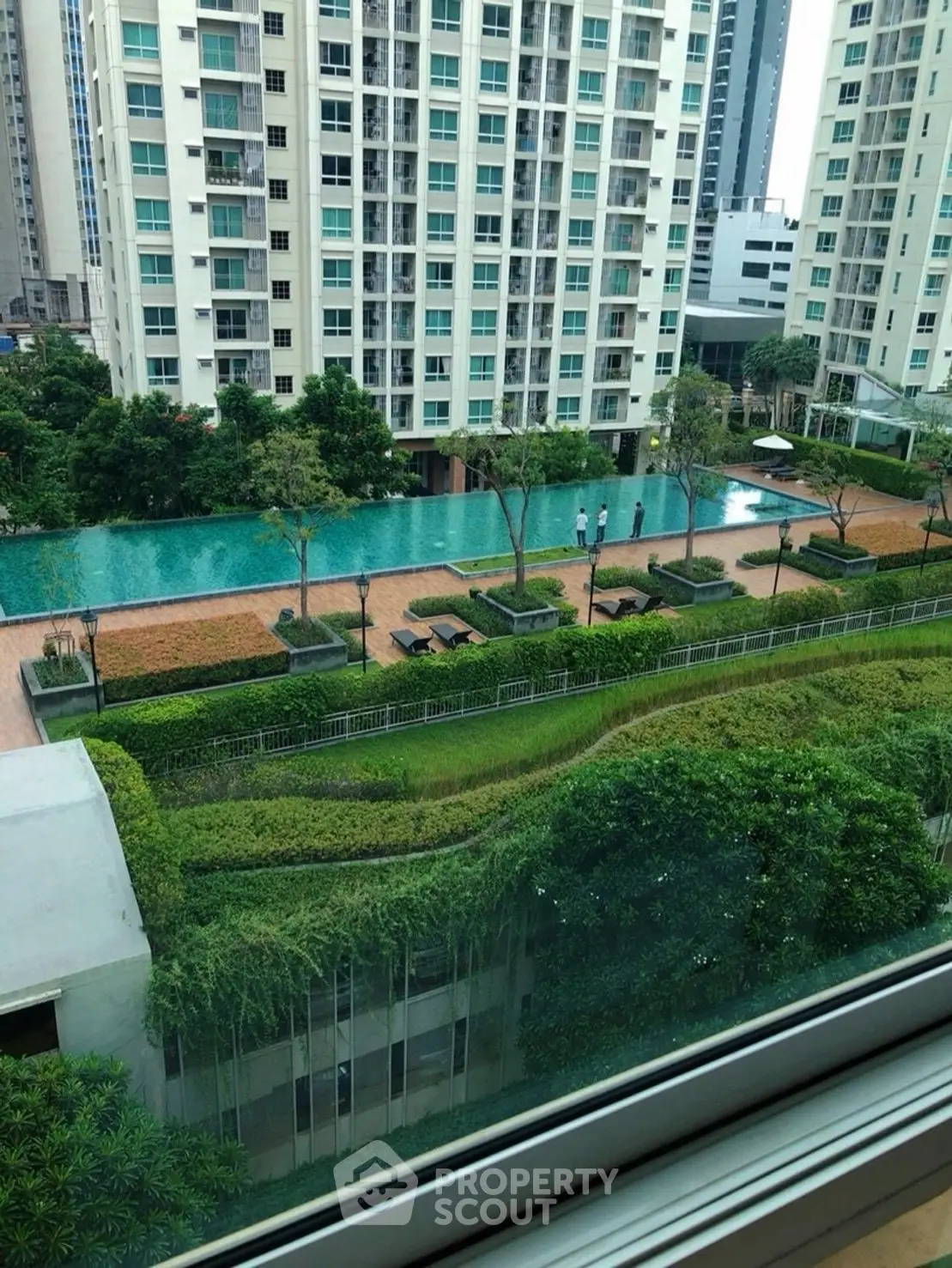 Luxurious high-rise apartment with stunning pool and lush garden view.