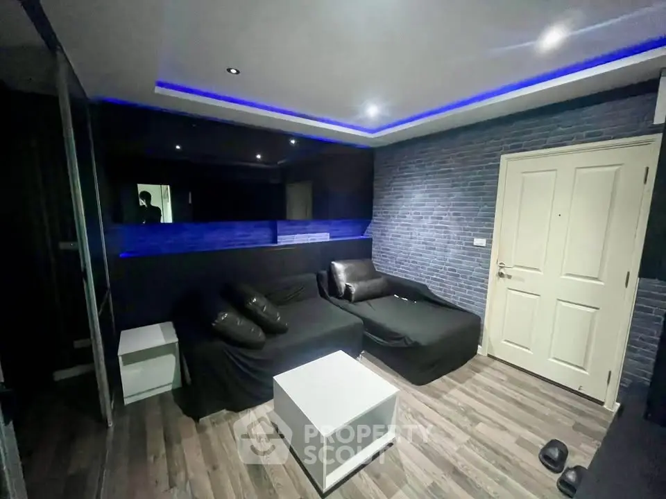 Modern living room with sleek black sofa and ambient blue lighting