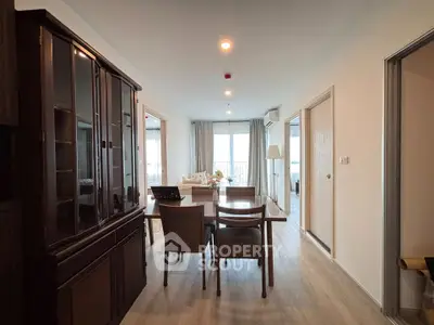Spacious dining area with elegant wooden furniture and natural light in modern apartment.