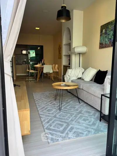 Modern open-plan living room with stylish decor and dining area, perfect for entertaining.