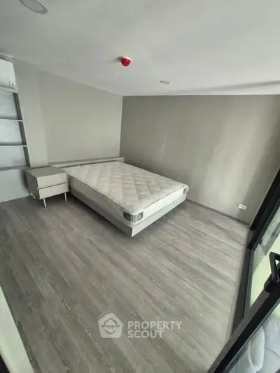 Spacious bedroom with modern design and large window for natural light.