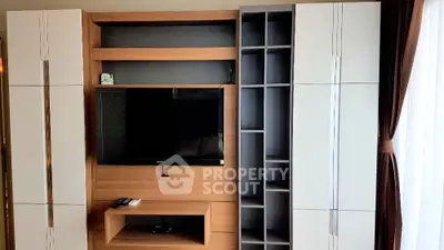 Modern living room with sleek TV unit and ample storage space, perfect for stylish urban living.