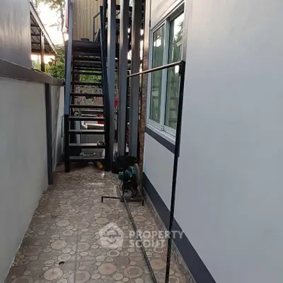 Modern exterior corridor with staircase and tiled pathway in a residential building