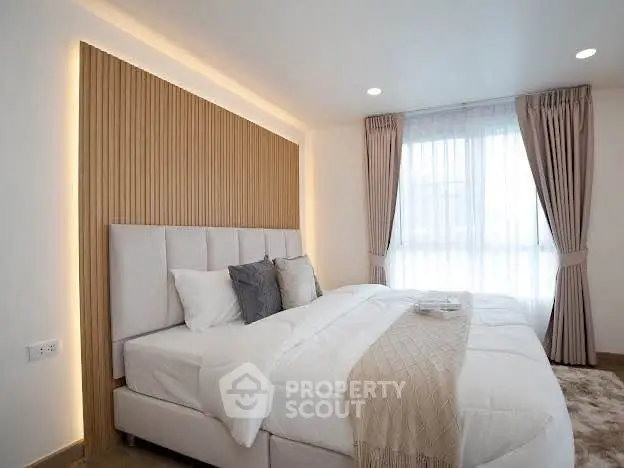 Luxurious bedroom with elegant decor and natural light, featuring a cozy bed and stylish curtains.