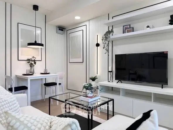 Modern living room with sleek furniture and stylish decor, featuring a TV and dining area.