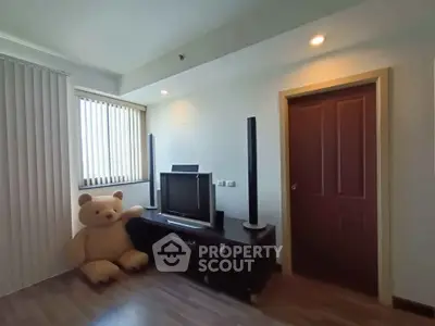 Cozy living room with TV and plush bear, perfect for relaxation.