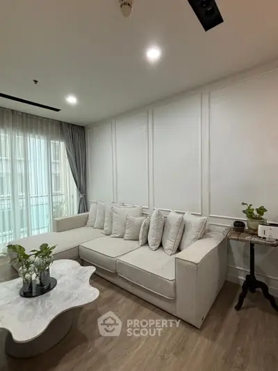 Elegant living room with modern decor and natural light, featuring a stylish sofa and chic coffee table.