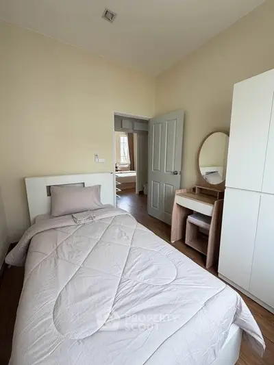 Cozy bedroom with single bed, modern furniture, and natural light.