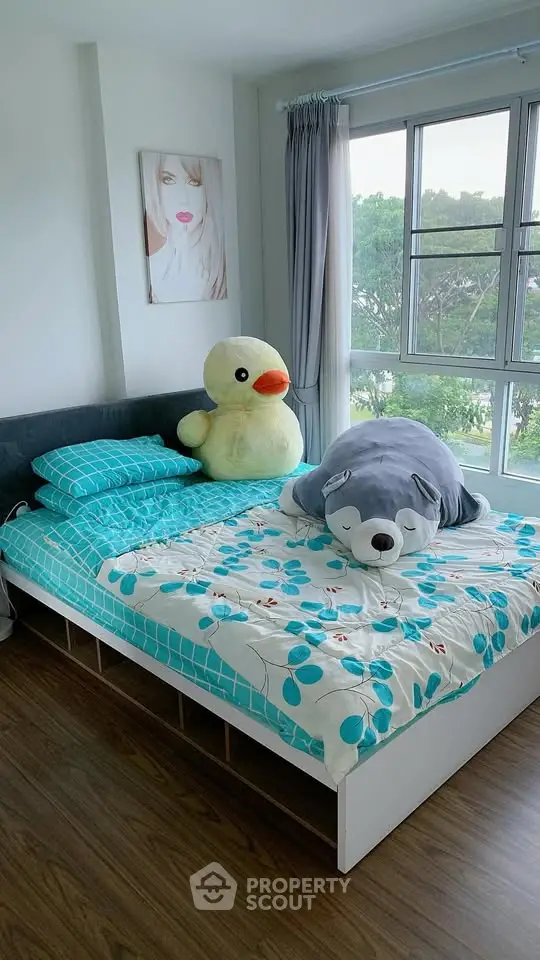 Cozy bedroom with plush toys and large windows offering a serene view.