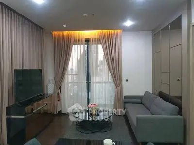 Elegant living room with modern decor and large window draped with curtains.