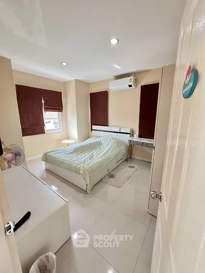 Cozy bedroom with air conditioning and natural light, perfect for relaxation.