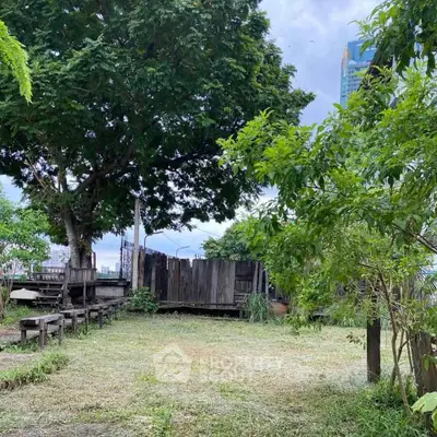 Charming garden space with lush greenery and rustic wooden fencing, perfect for outdoor relaxation.