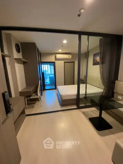 Modern studio apartment with glass partition, cozy bedroom, and stylish furnishings