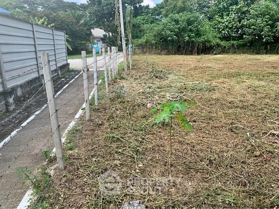 Vacant land plot with potential for development, surrounded by greenery and a quiet neighborhood.