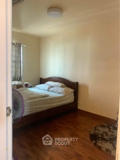 Cozy bedroom with wooden flooring and natural light