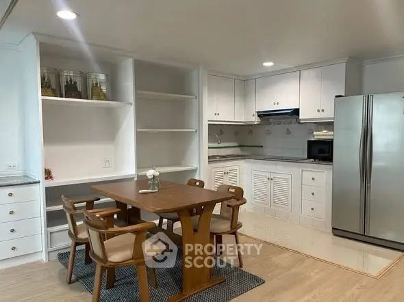 Charming kitchen with wooden dining set and modern appliances in cozy apartment.