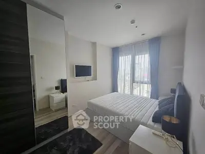 Modern bedroom with large window and stylish decor in a contemporary apartment.