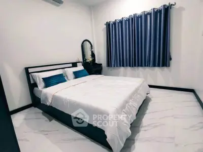 Spacious bedroom with modern decor and elegant blue curtains