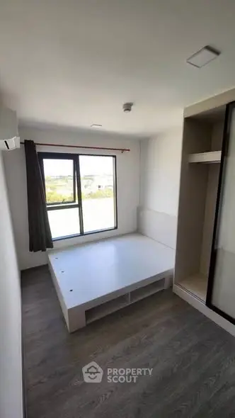 Modern minimalist bedroom with large window and built-in storage