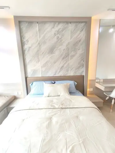 Modern bedroom with stylish headboard and cozy bedding in a bright apartment.